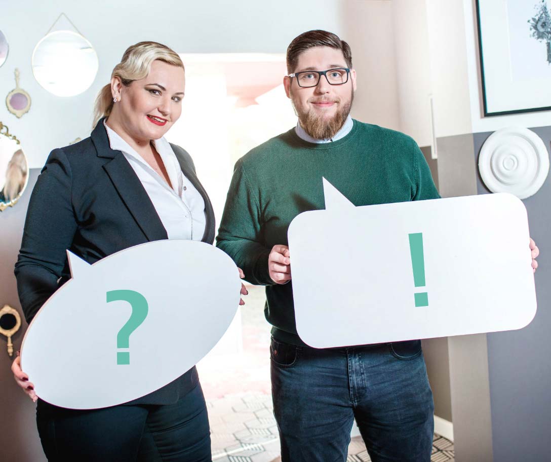 FAQ Foto: Zwei Personen (weiblich und männlich) halten jeweils ein Schild in der hand mit einem Fragezeichen bzw. einem Ausrufezeichen